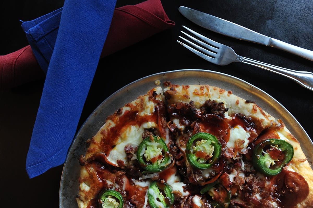 Bold, satisfying Muscle Man pizza is topped with jalapeño cream cheese, mozzarella cheese, Italian sausage, bacon and pepperoni -- all drizzled with a chipotle raspberry glaze and finished with fresh, thinly sliced jalapeños -- Nov. 13 at the South Pacific Cafe in Battle Ground.