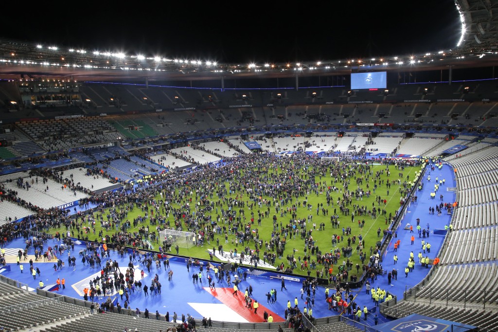 Spectators invade the pitch of the Stade de France stadium after the international friendly soccer France against Germany, Friday, Nov. 13, 2015 in Saint Denis, outside Paris. At least 35 people were killed in shootings and explosions around Paris, many of them in a popular theater where patrons were taken hostage, police and medical officials said Friday.  Two explosions were heard outside the Stade de France stadium.