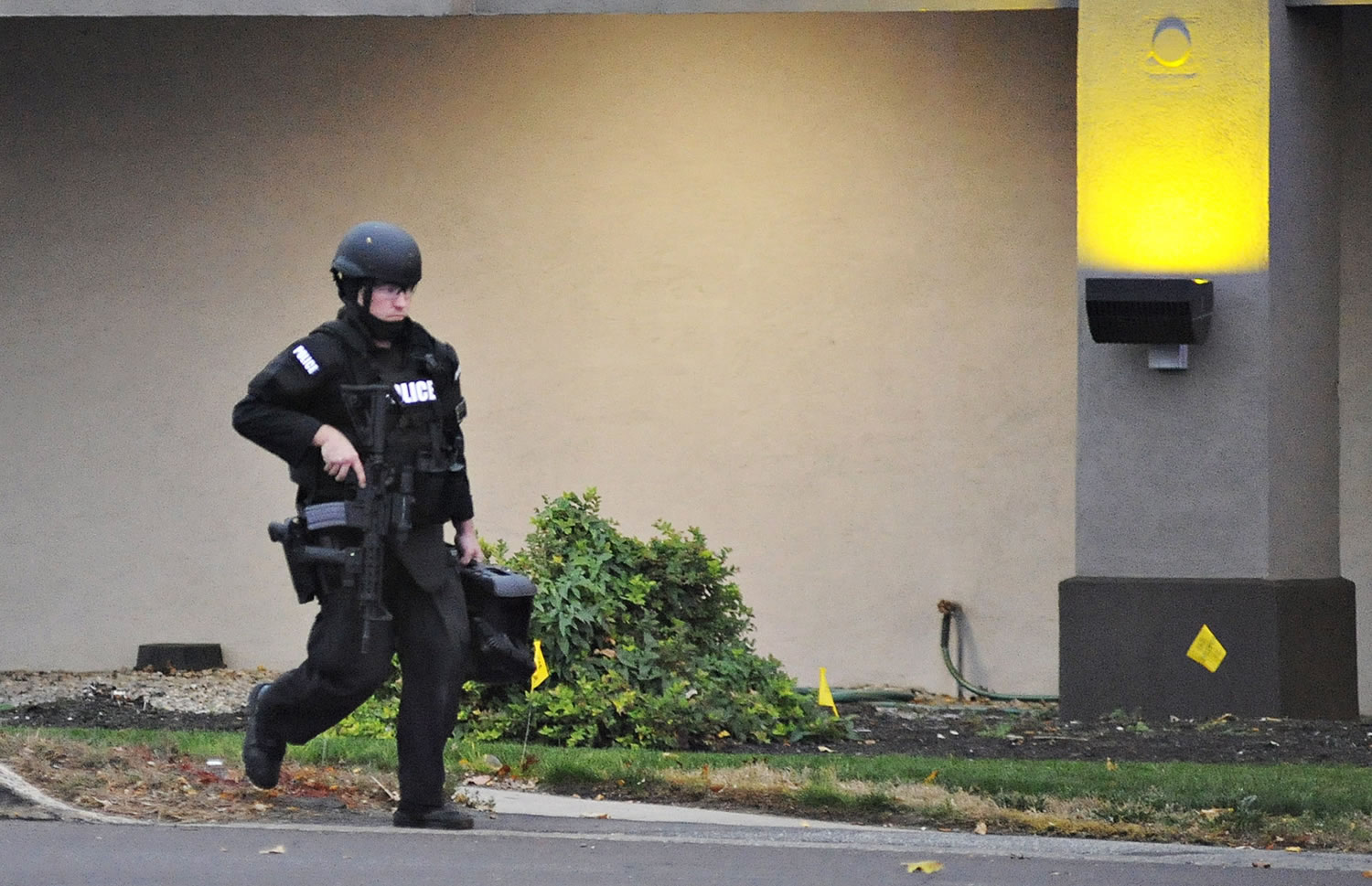 A police officer walks in front of the Knights Inn after reports of a shooting at the motel in Bensalem Township, near Trevose, Pa., on Saturday. Police seeking someone on a parole violation stumbled upon another man and a woman who were wanted in a double homicide in North Carolina. That man apparently killed himself at the motel after firing at police, authorities said Saturday.