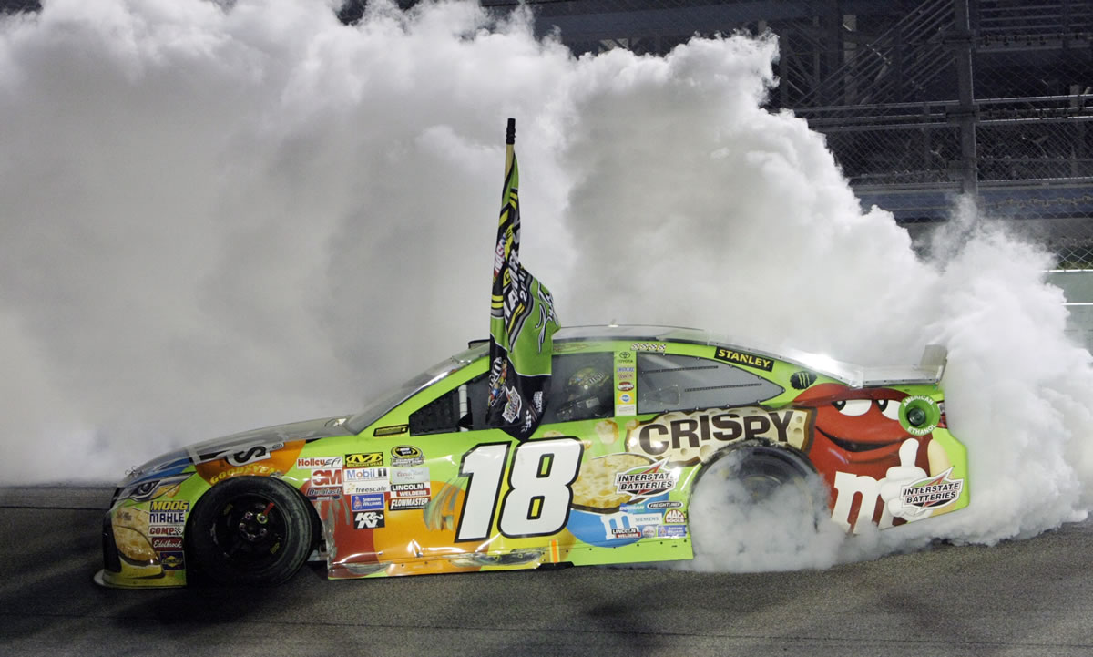 Kyle Busch  does a burnout after winning the NASCAR Sprint Cup Series auto race and the season title, Sunday, Nov. 22, 2015, at Homestead-Miami Speedway in Homestead, Fla.
