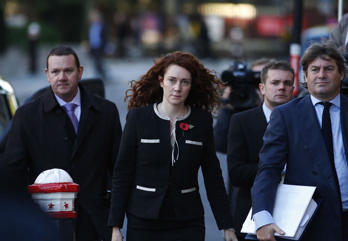 Former News of the World editor Rebekah Brooks, center, along with her husband Charlie, right, arrives at Central Criminal Court in London on Tuesday.
