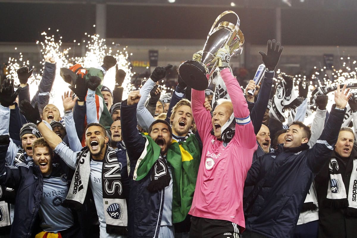 Sporting Kansas City goalkeeper Jimmy Nielsen, center, hoists the MLS Cup as he and his teammates celebrate their 2-1 win over Real Salt Lake on Saturday.