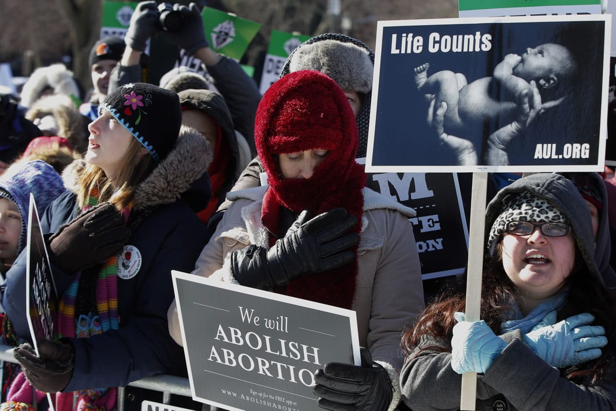 Anti-abortion demonstrators put their hands to their hearts as they recite the Pledge of Allegiance as they rally at the annual March for Life on Wednesday on the National Mall in Washington.