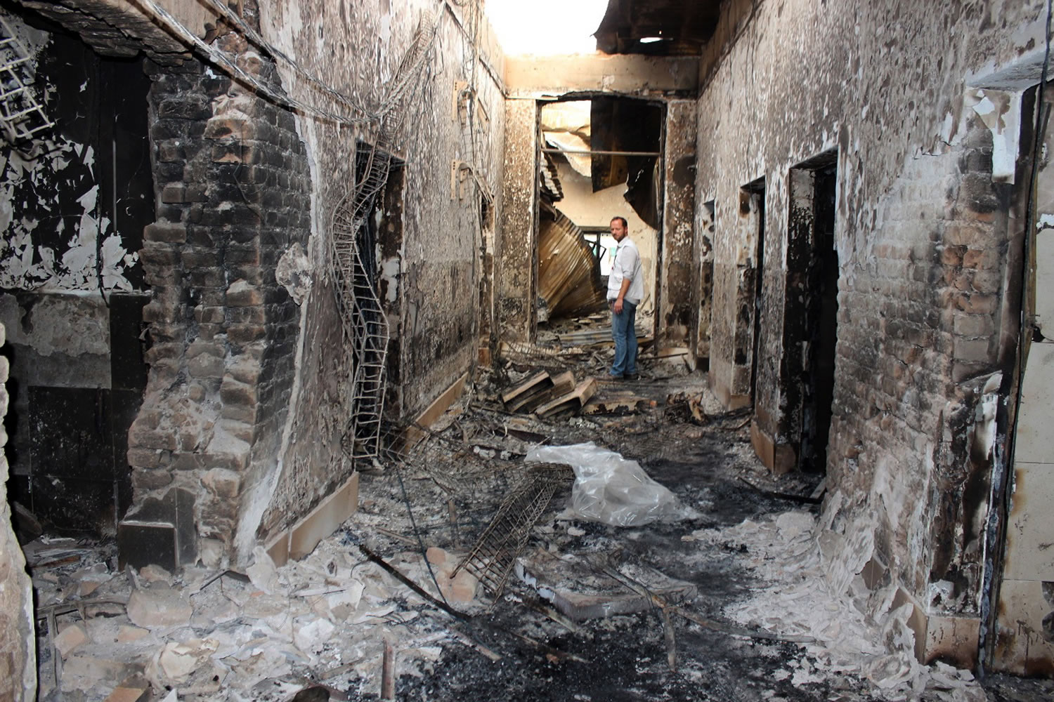 An employee of Doctors Without Borders stands inside the charred remains of its hospital in Kunduz, Afghanistan, on Oct. 16. The facility was hit by a U.S. airstrike on Oct. 3.