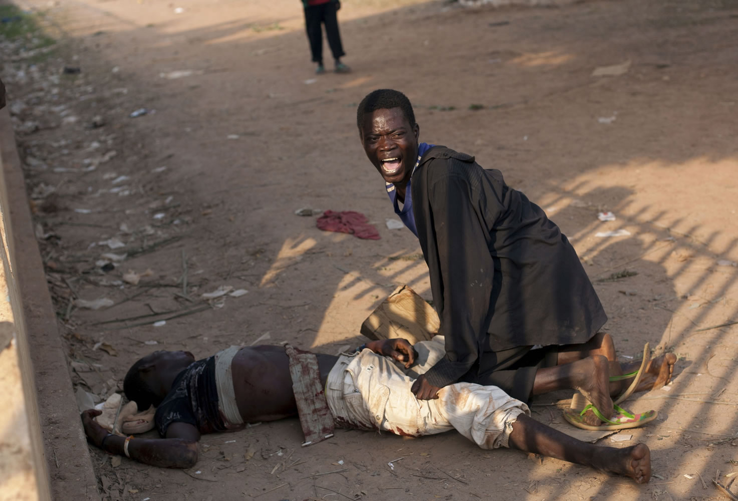 A young man cries out after his friend was badly injured by passing Chadian troops during a protest Dec.