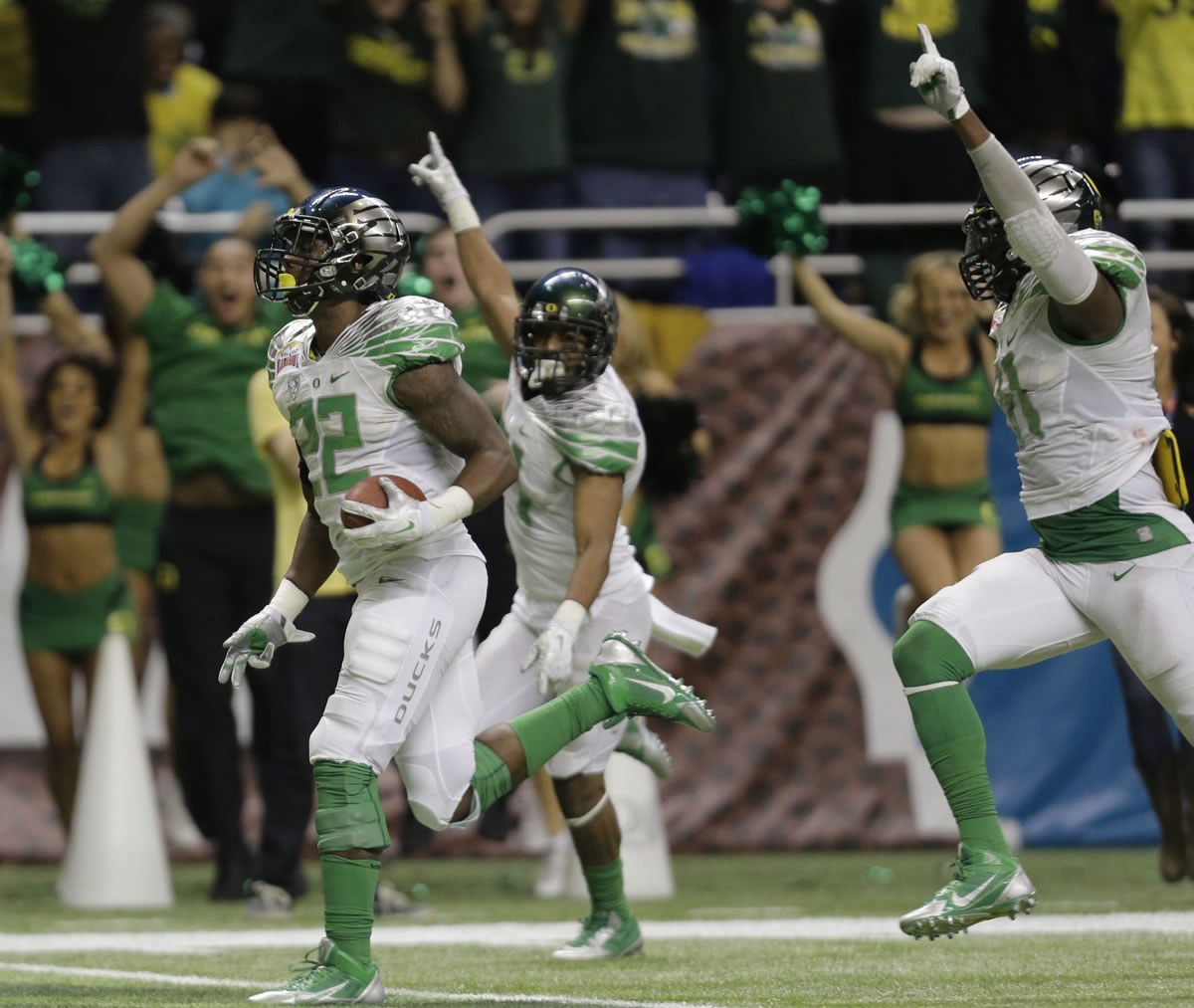 Oregon's Derrick Malone (22) returns an interception for a touchdown against Texas during the second half of the Valero Alamo Bowl NCAA college football game, Monday,  Dec. 30, 2013, in San Antonio.
