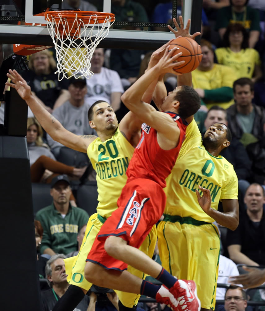 Oregon's Waverly Austin, left, fouls Arizona's Aaron Gardon as he defends the basket with teammate Oregon's Mike Moser, right, during the first half of an NCAA college basketball game in Eugene, Ore. on Saturday, March 8, 2014.