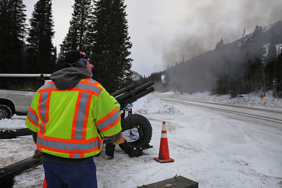 A Colorado Department of Transportation employee uses an explosives launcher Feb. 21 to try to trigger a controlled avalanche, near Empire, Colo.