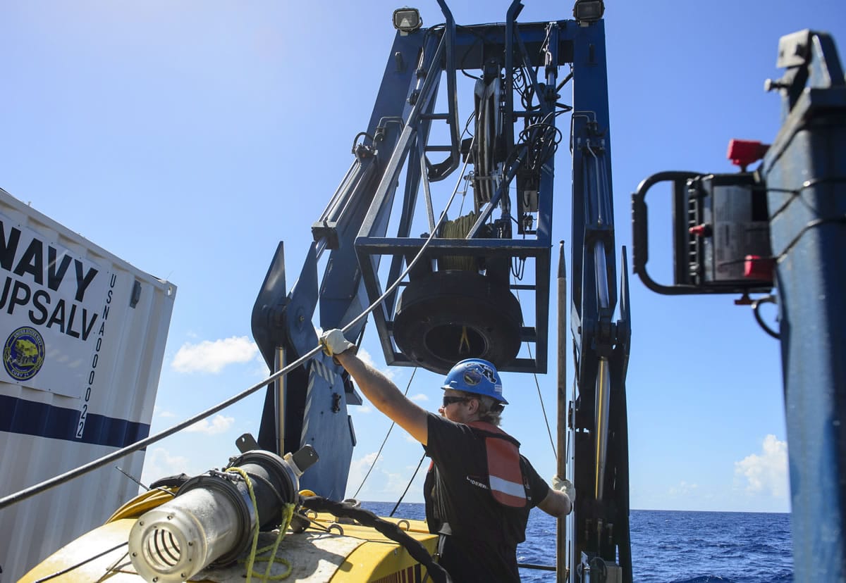 Tucker Bailey guides a towline through the A-frame while deploying the tow pinger aboard USNS Apache. USNS Apache departed Norfolk, Va., on Oct. 19, to begin searching for wreckage from the missing cargo ship El Faro. El Faro lost power and went down east of the Bahamas during Hurricane Joaquin.