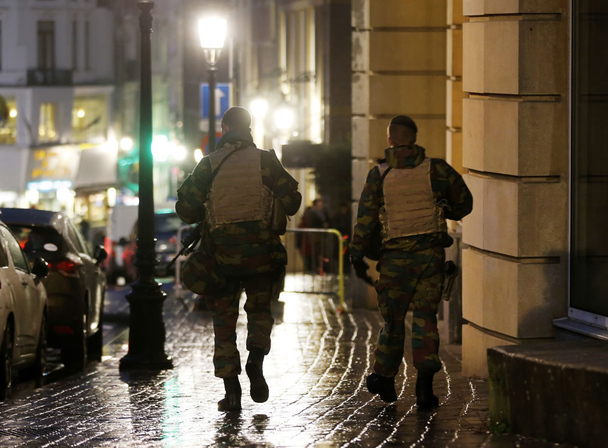Belgian police officers walk along a road in central Brussels, Belgium, on Tuesday. The Belgian capital Brussels has entered its fourth day of lockdown, with schools and underground transport shut and more than 1,000 security personnel deployed across the country.