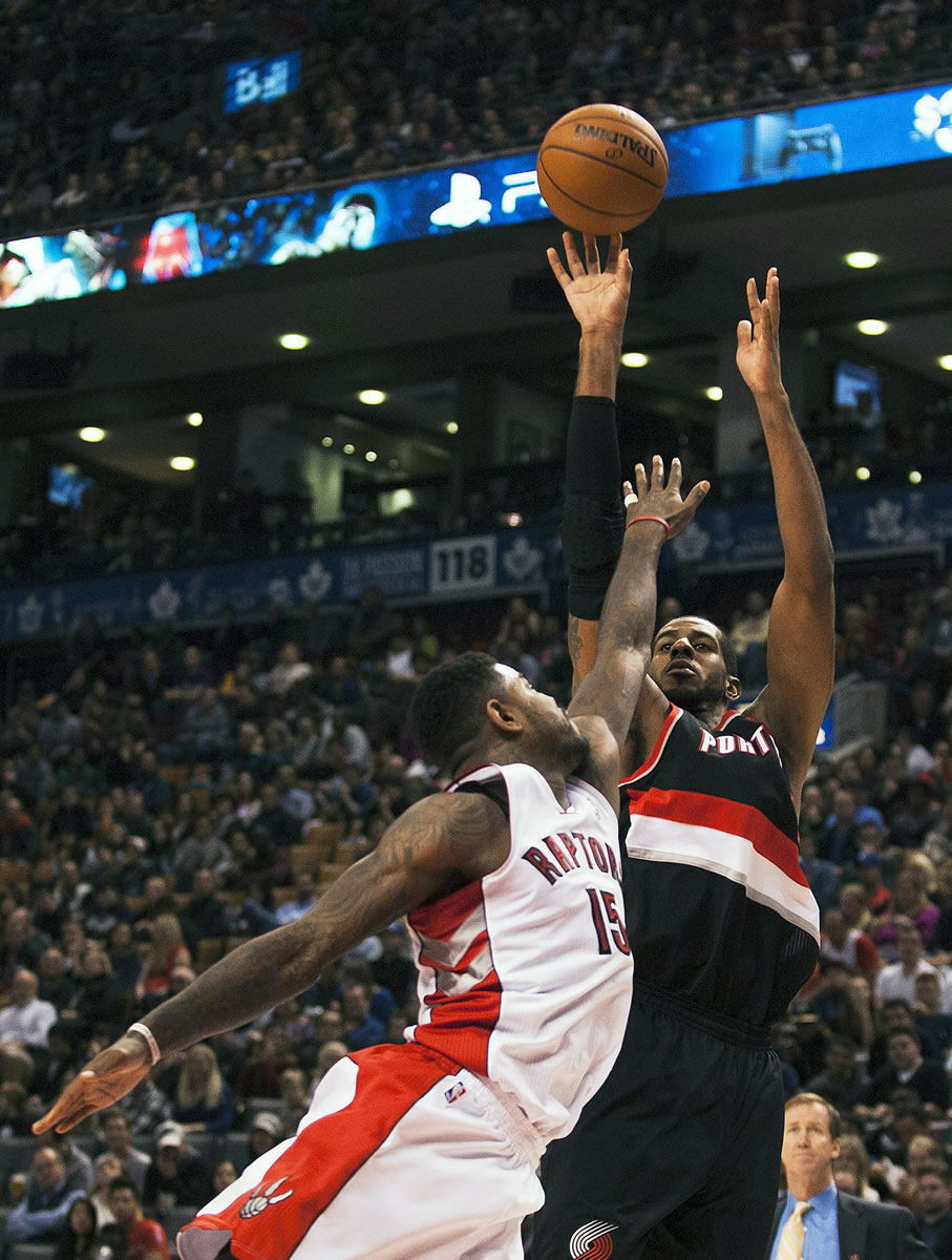 Portland Trail Blazers' LaMarcus Aldridge goes up for a shot against Toronto Raptors' Amir Johnson on Sunday. Aldridge had his fifth consecutive double-double with 25 points and 11 rebounds in Portland's 118-110 overtime victory at Toronto.