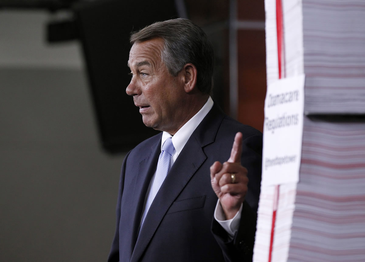 House Speaker John Boehner of Ohio gestures toward a stack of paper representing the 20,000 pages of Affordable Health Care Act regulations during a news conference May 16 on Capitol Hill in Washington.