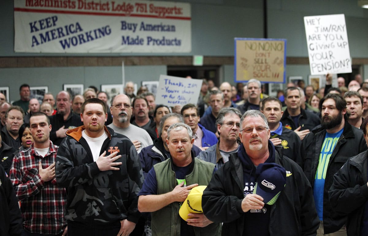 Machinists union members and supporters hold their right hands over their hearts as they recite the Pledge of Allegiance to begin a rally asking members to vote against a proposed contract Thursday in Seattle.