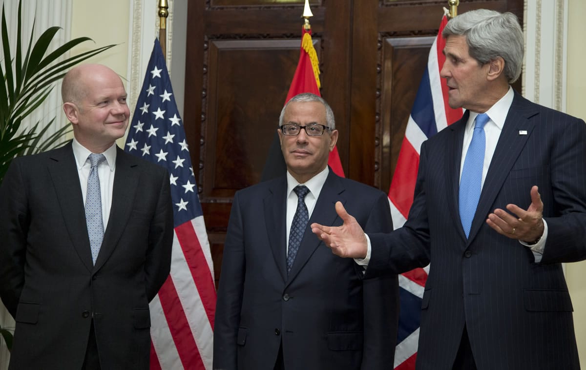 U.S. Secretary of State John Kerry, right, gestures Sunday as he talks to the media as Libya Prime Minister Ali Zeidan, centre, and British Foreign Secretary William Hague, look on, at Winfield House, the residence of the U.S. Ambassador to Britain, in London.