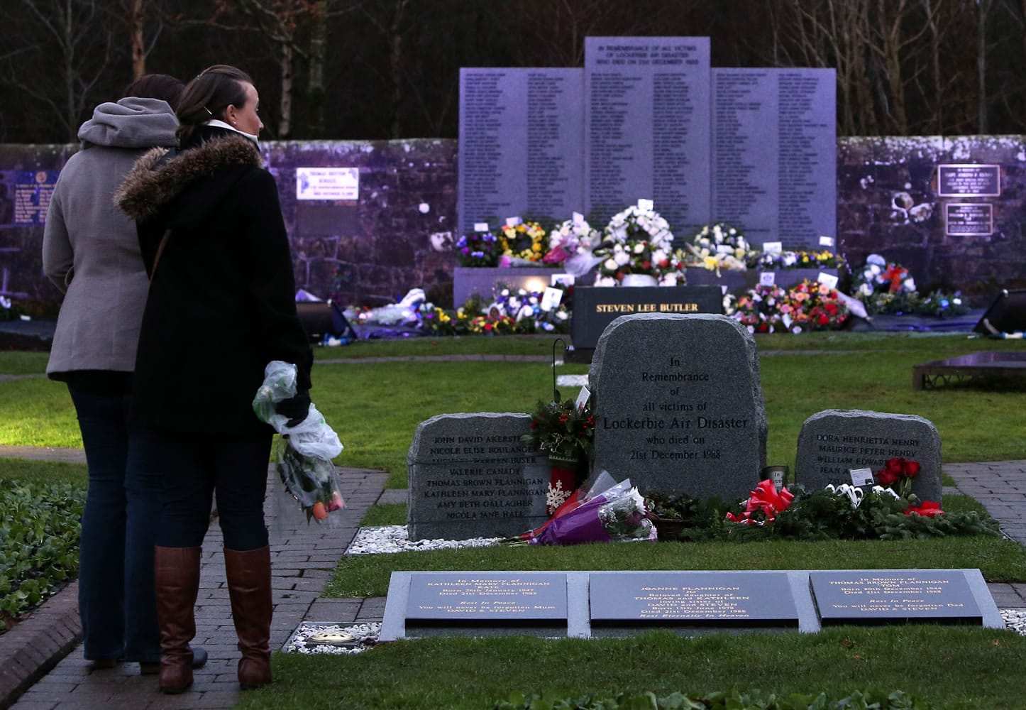 Members of the public visit the main memorial stone in memory of the victims of the Pan Am flight 103 bombing Saturday in the garden of remembrance at Dryfesdale Cemetery, near Lockerbie, Scotland.