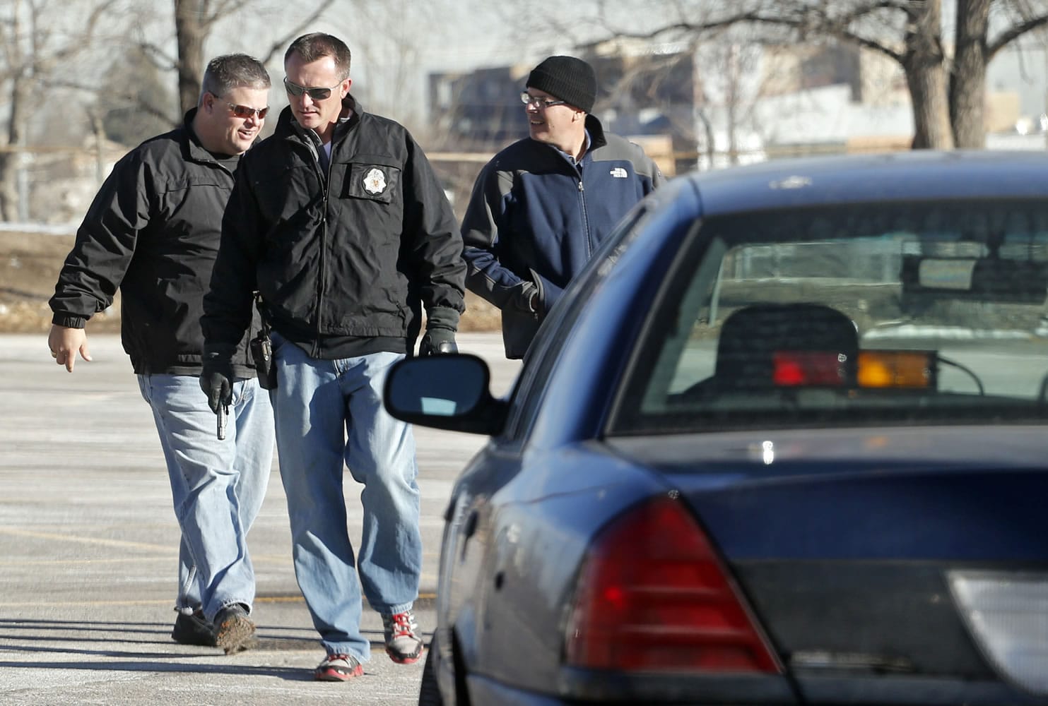 Denver Police detectives investigate the scene of a stabbing on Friday in a parking lot adjacent to Sports Authority Stadium where three people were stabbed during a fight after an NFL football game between San Diego and Denver on Thursday.