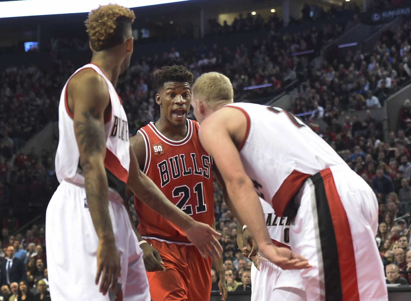 Chicago Bulls guard Jimmy Butler (21) and Portland Trail Blazers center Mason Plumlee (24) exchange words during the fourth quarter of an NBA basketball game in Portland, Ore., Tuesday, Nov 24, 2015. The Bulls won 93-88.