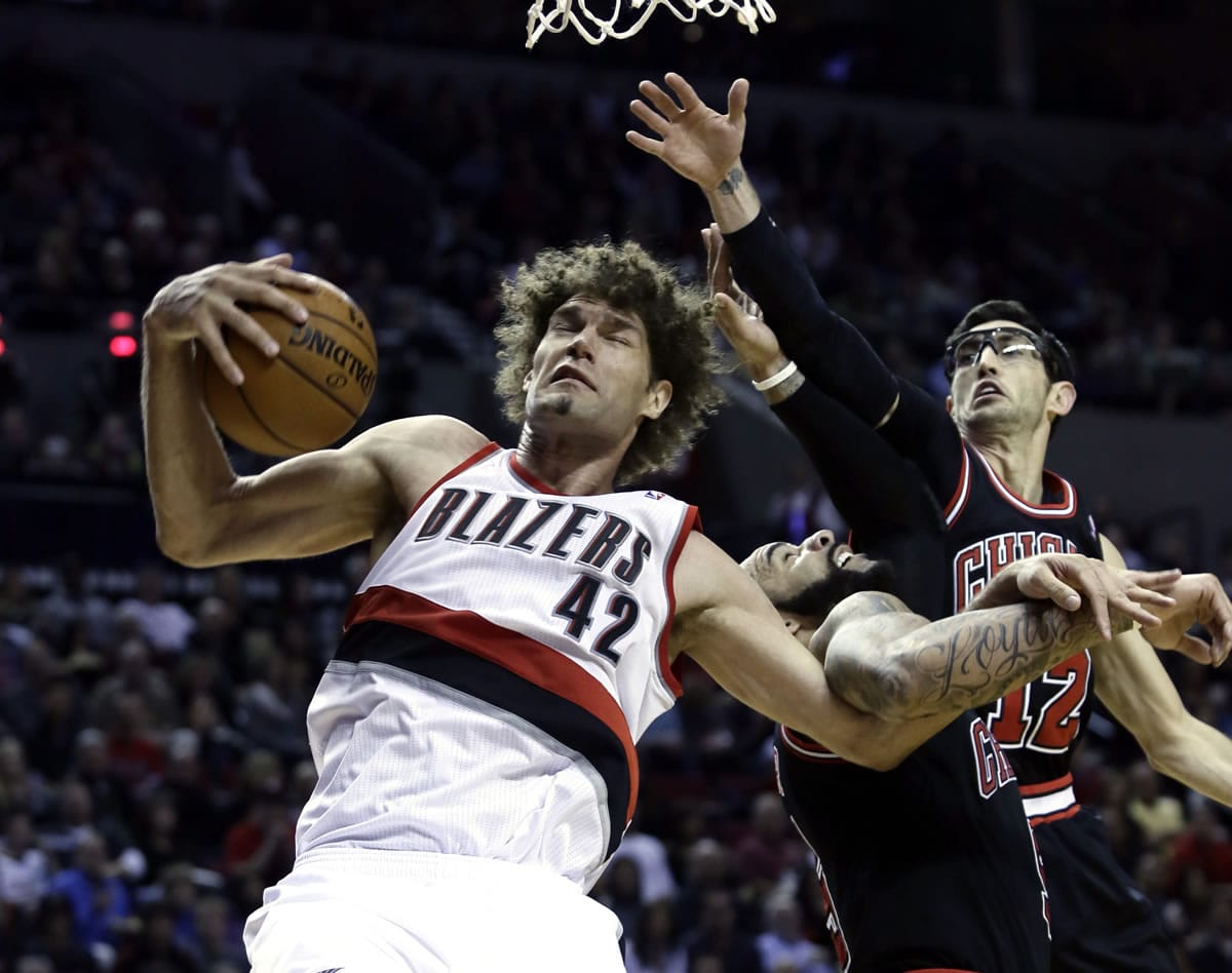 Blazers center Robin Lopez, left, pulls in an offensive rebound against the Chicago Bulls' Kirk Hinrich, right, and Carlos Boozer during the second half Friday.