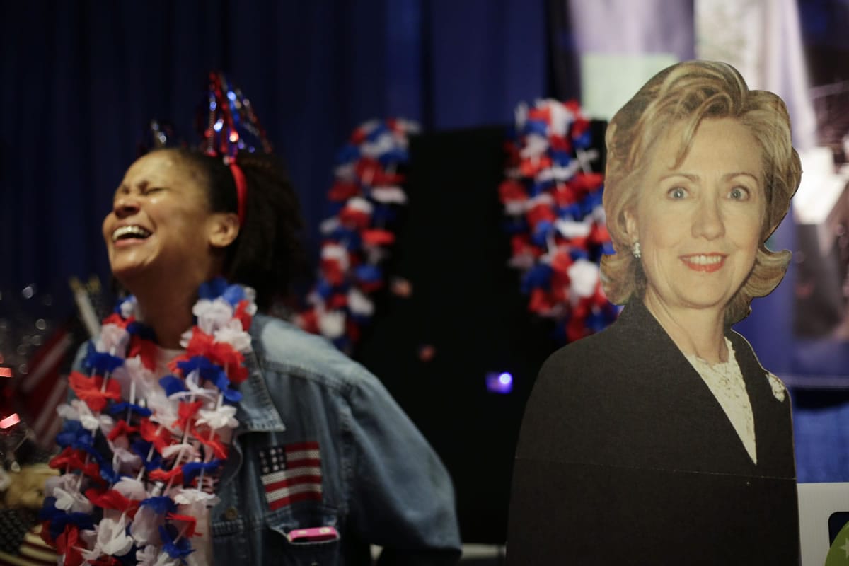 Exhibitor Dowa Ross, left, laughs while standing next to the cardboard cutout of former first lady Hillary Rodham Clinton at the California Democrats State Convention on Friday in Los Angeles.