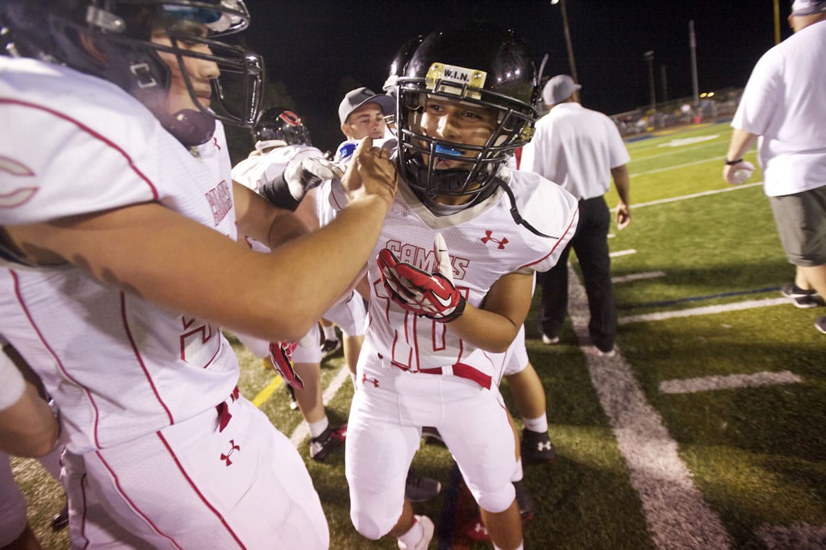 Jordan Del Moral is congratulated by teammates after scoring his first varsity touchdown on Sept. 13 against Canby.