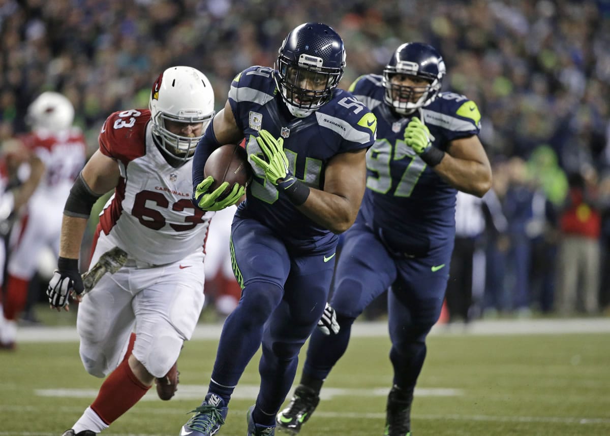 Seattle Seahawks middle linebacker Bobby Wagner (54) returns an Arizona Cardinals fumble for a touchdown as Cardinals' Lyle Sendlein (63) pursues during the second half of an NFL football game, Sunday, Nov. 15, 2015, in Seattle.