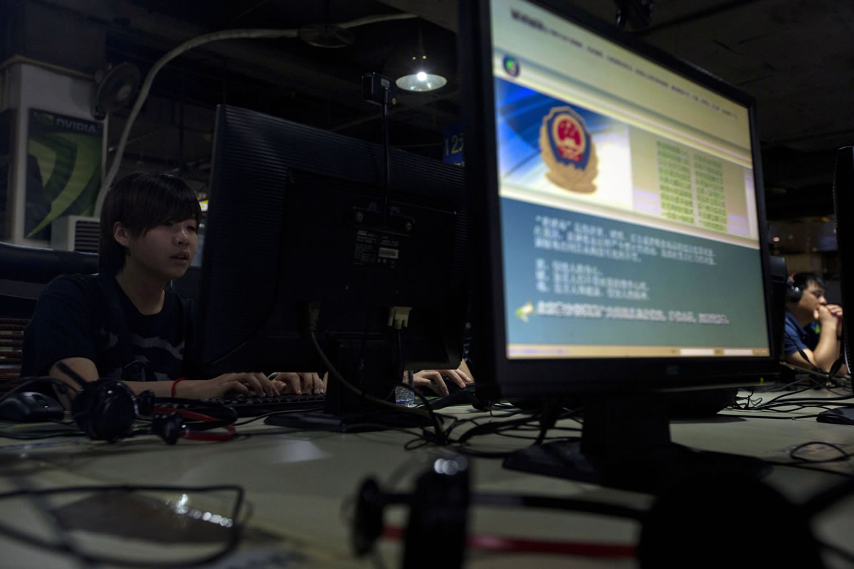 Files/Associated Press
Computer users sit near a display with a message from the Chinese police on the proper use of the Internet at an Internet cafe in Beijing.