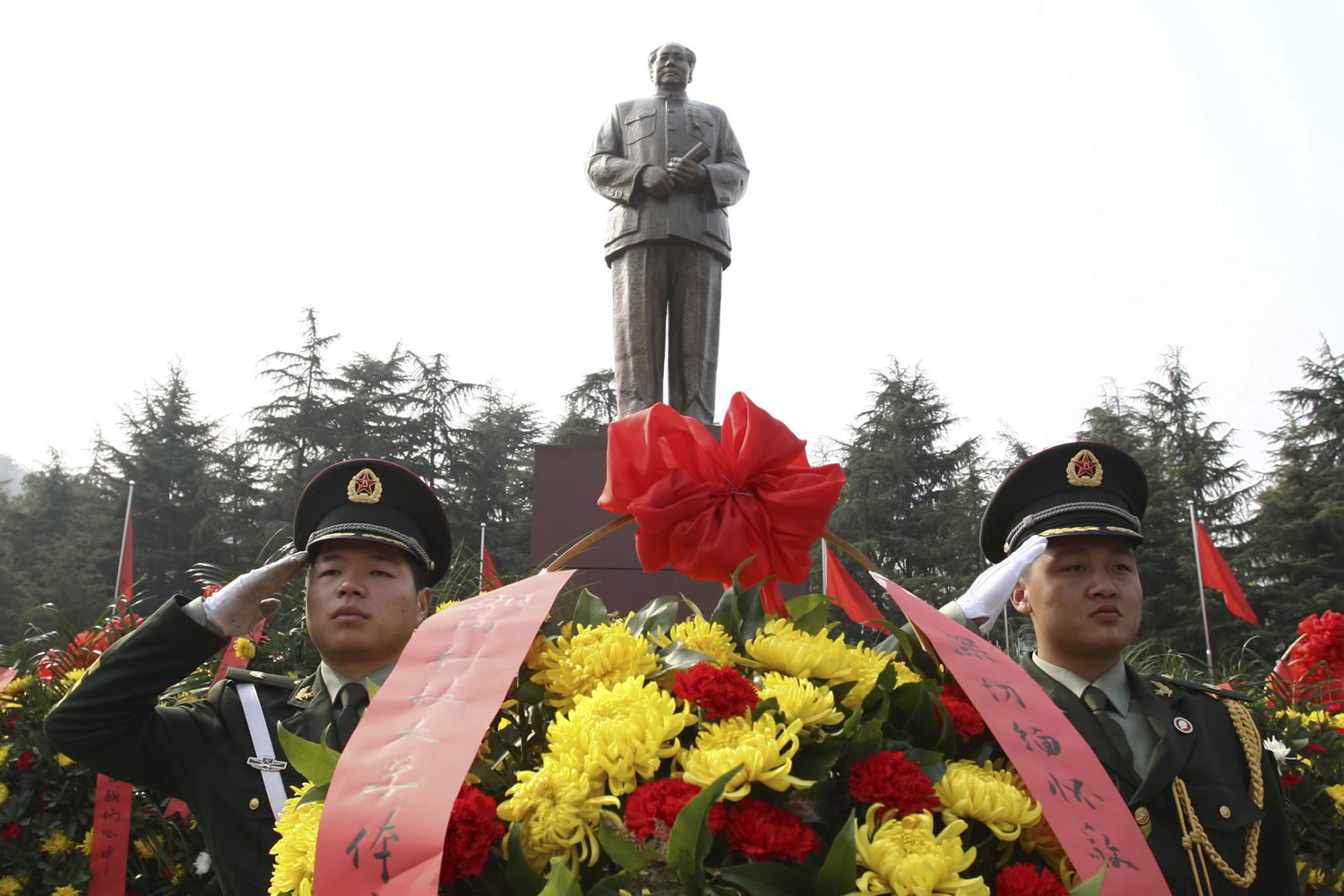 Associated Press
Security guards salute Wednesday near wreaths in front of a statue of the late Communist leader Mao Zedong in Shaoshan, Mao's hometown, in southern China's Hunan province.
