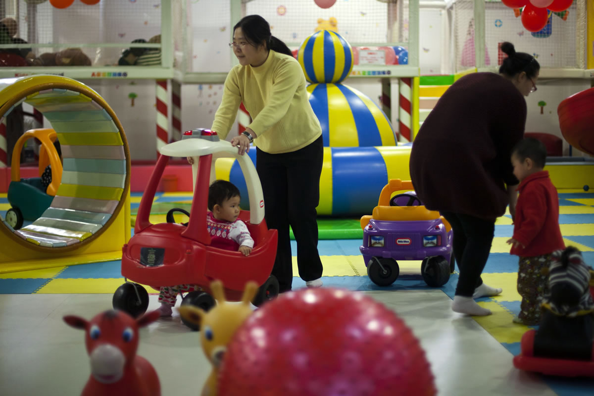 Parents play with their children at a kid's play area in a shopping mall in Beijing.