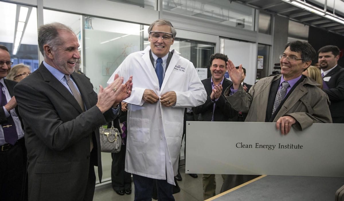 Gov. Jay Inslee tries on his own monogrammed lab coat Thursday before he tours a University of Washington building where clean-tech research is being conducted. Inslee attended the kickoff of the Clean Energy Institute.
