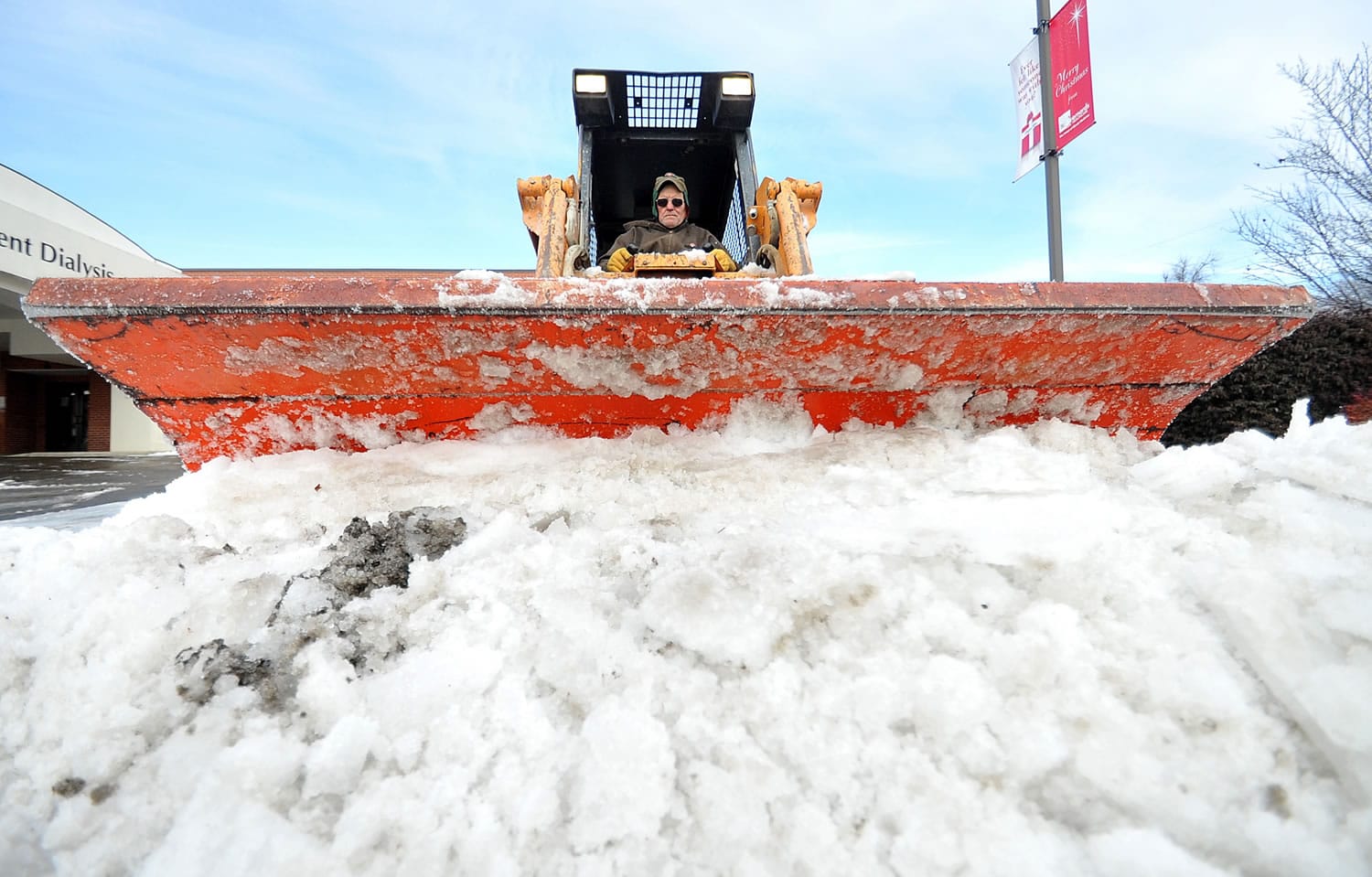 Ronnie Moody of Nabholz Construction Services plows ice from a parking lot Saturday in downtown Jonesboro, Ark.