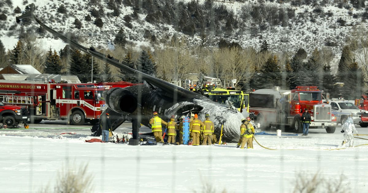 Emergency crews work Sunday near a passenger plane that crashed upon landing at the Aspen-Pitkin County Airport in Aspen, Colo.
