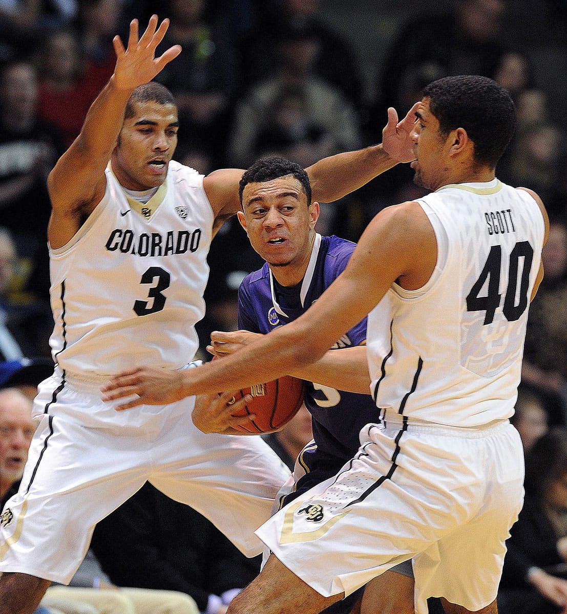 Xavier Talton, left, of Colorado, and Josh Scott (40), trap Nigel Williams-Goss of Washington during the first half of an NCAA college basketball game in Boulder, Colo., Sunday, Feb. 9, 2014.