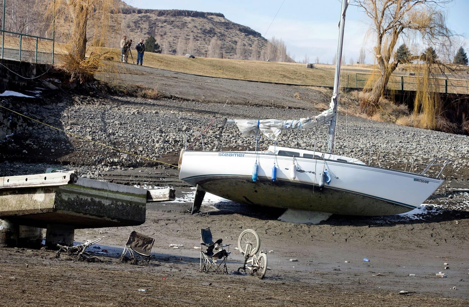 A sailboat is left in the mud at the Vantage Riverstone Resort dock in Vantage on Monday as up to 20 feet of water is let out of the Columbia River reservoir behind Wanapum Dam after a spillway pillar was discovered to be cracked at the dam last week.