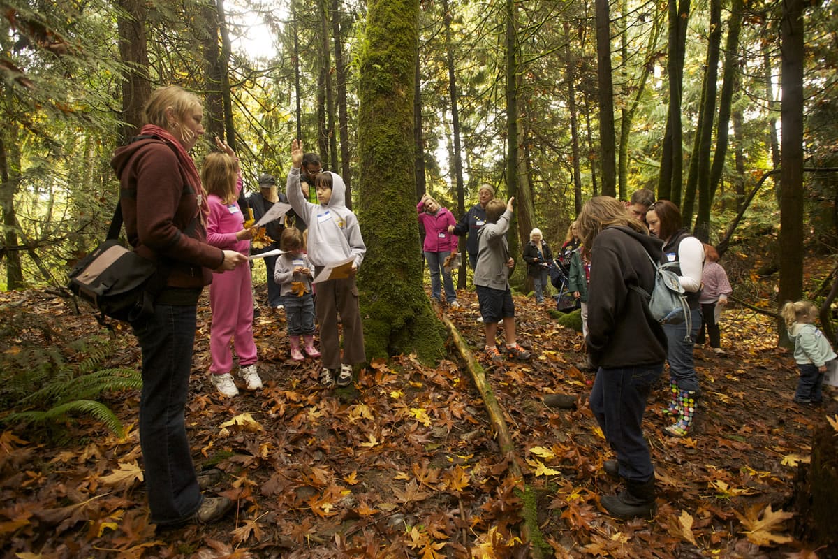 Lauriel Schuman, left, leads a guided mushroom hunting hike at last year's Columbia Springs Family Field Trip Day.