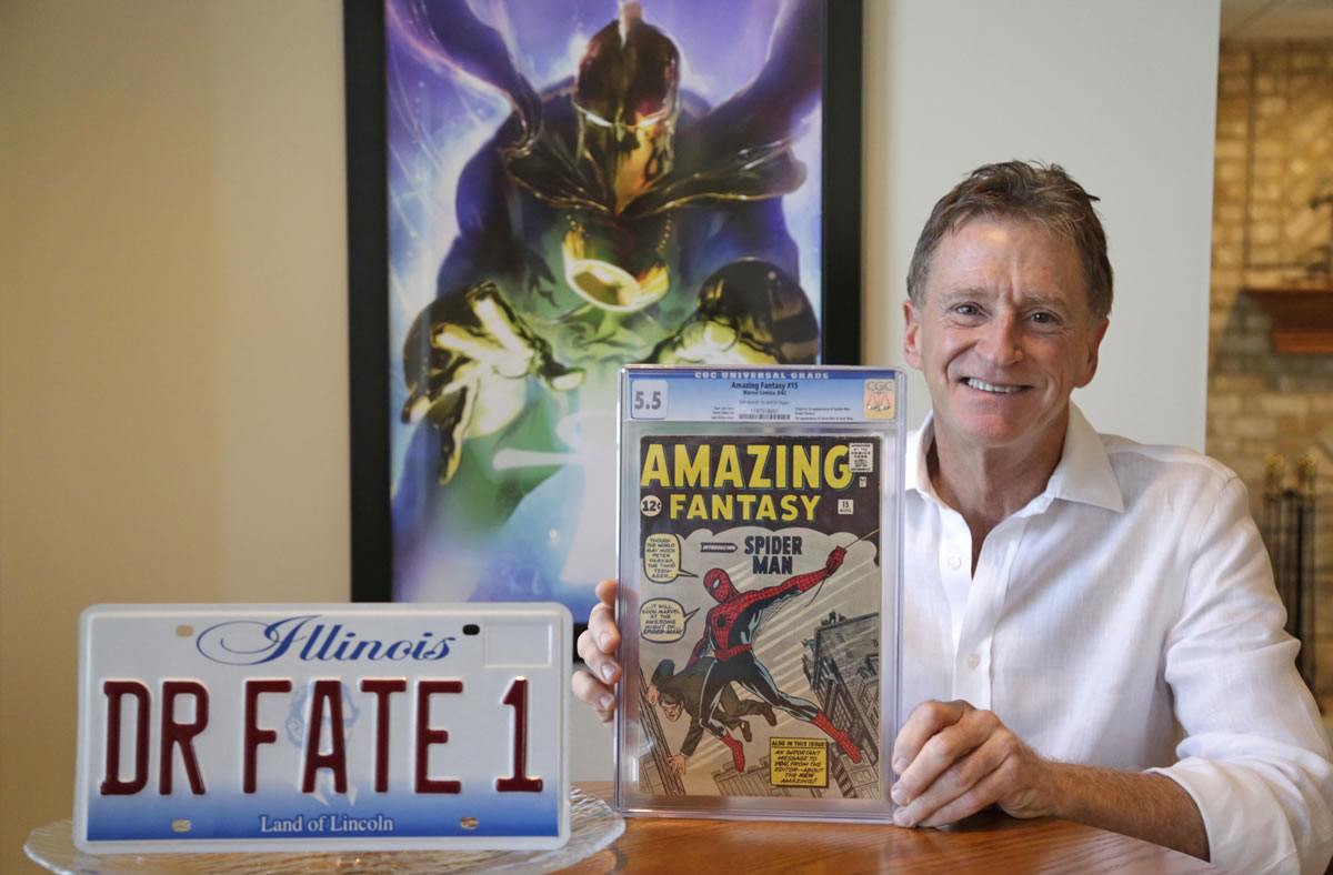 Steve Landman displays one of his comic books, a vanity license plate with the name of a superhero, and a poster of the same superhero, Dr.