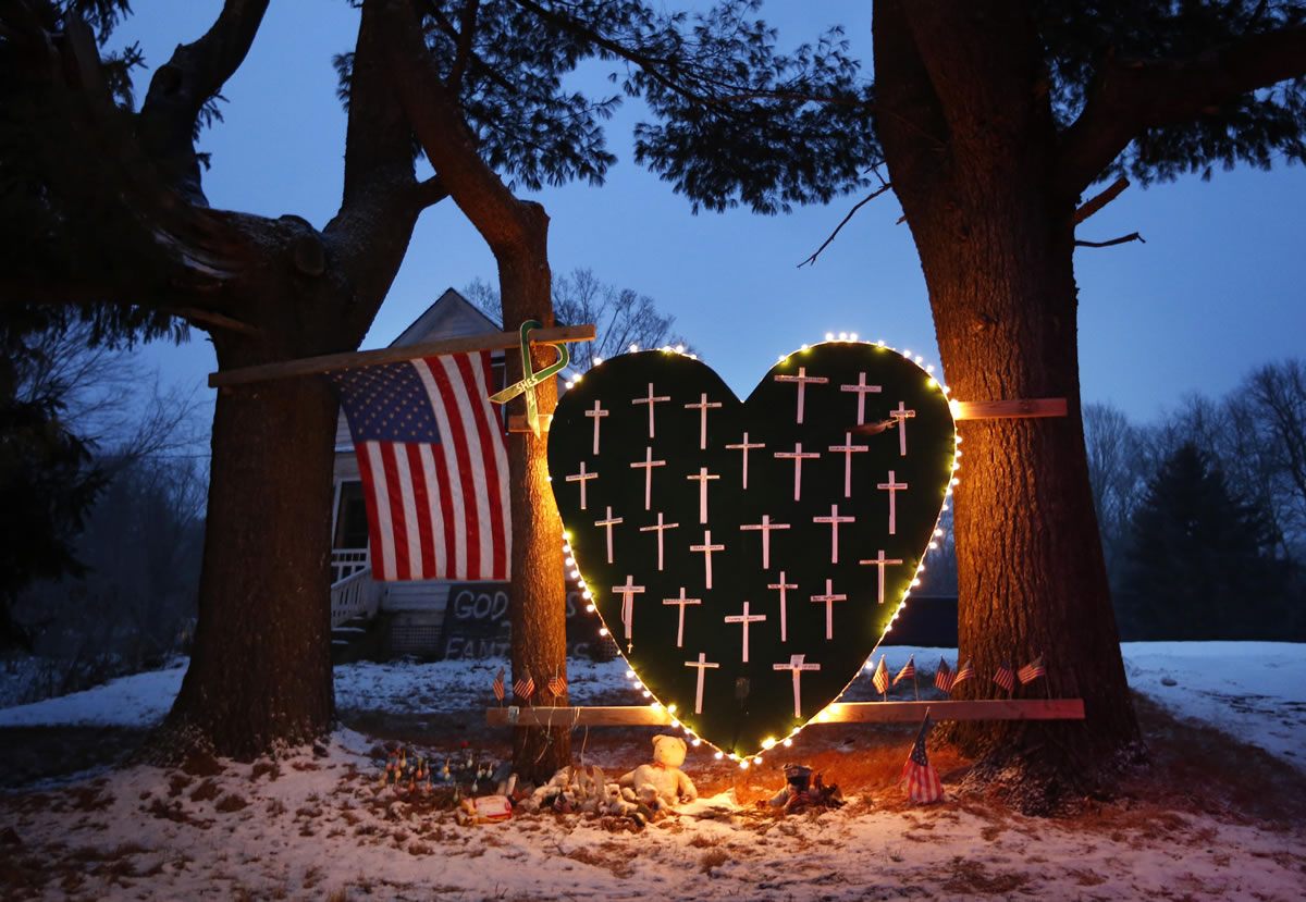 A makeshift memorial with crosses for the victims of the Sandy Hook massacre stands outside a home in Newtown, Conn., on Saturday, the one-year anniversary of the shootings.