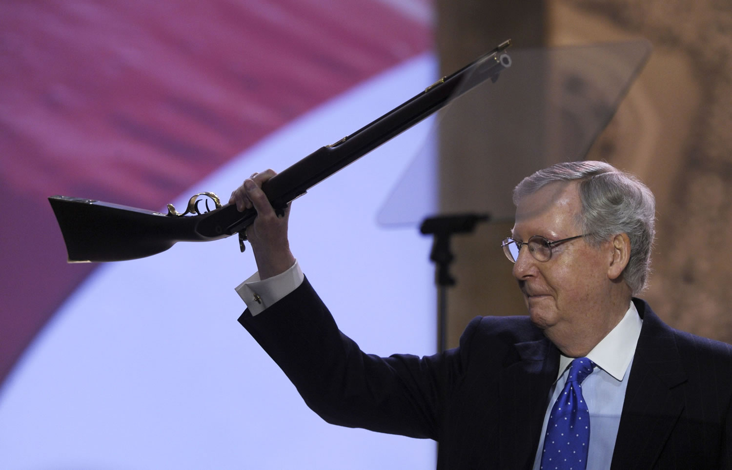 Senate Minority Leader Mitch McConnell of Kentucky walks onto the stage holding a rifle before speaking at the Conservative Political Action Committee annual conference at National Harbor, Md., on Thursday.