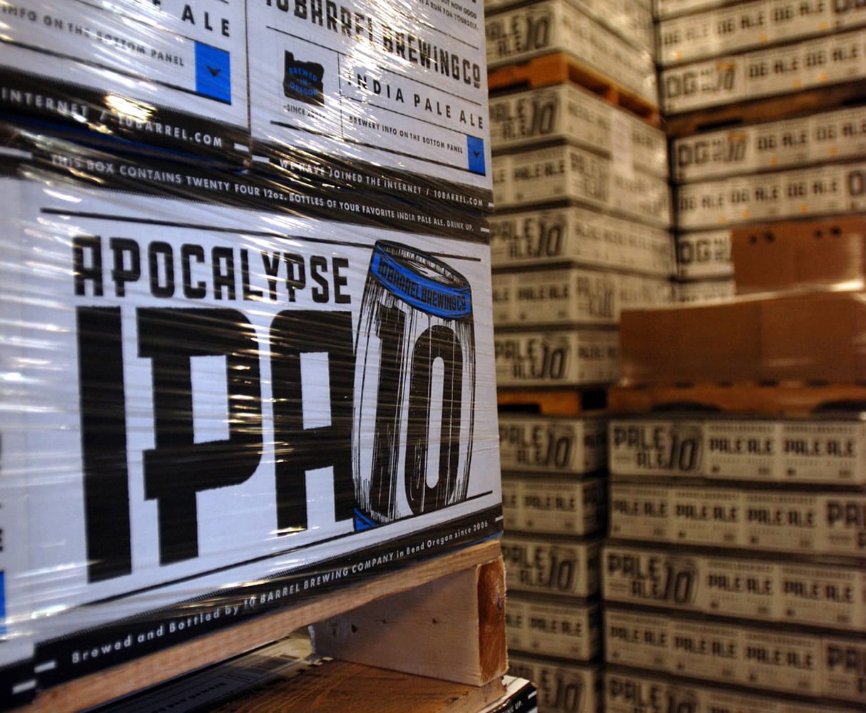 Cases of Apocalypse IPA from 10 Barrel Brewing Co. await shipment in 2014 in Bend, Ore. A year after the Cox brothers sold 10 Barrel to global beer Goliath Anheuser-Busch InBev, the pair are still gainfully employed and 10 Barrel is still producing award-winning beer.