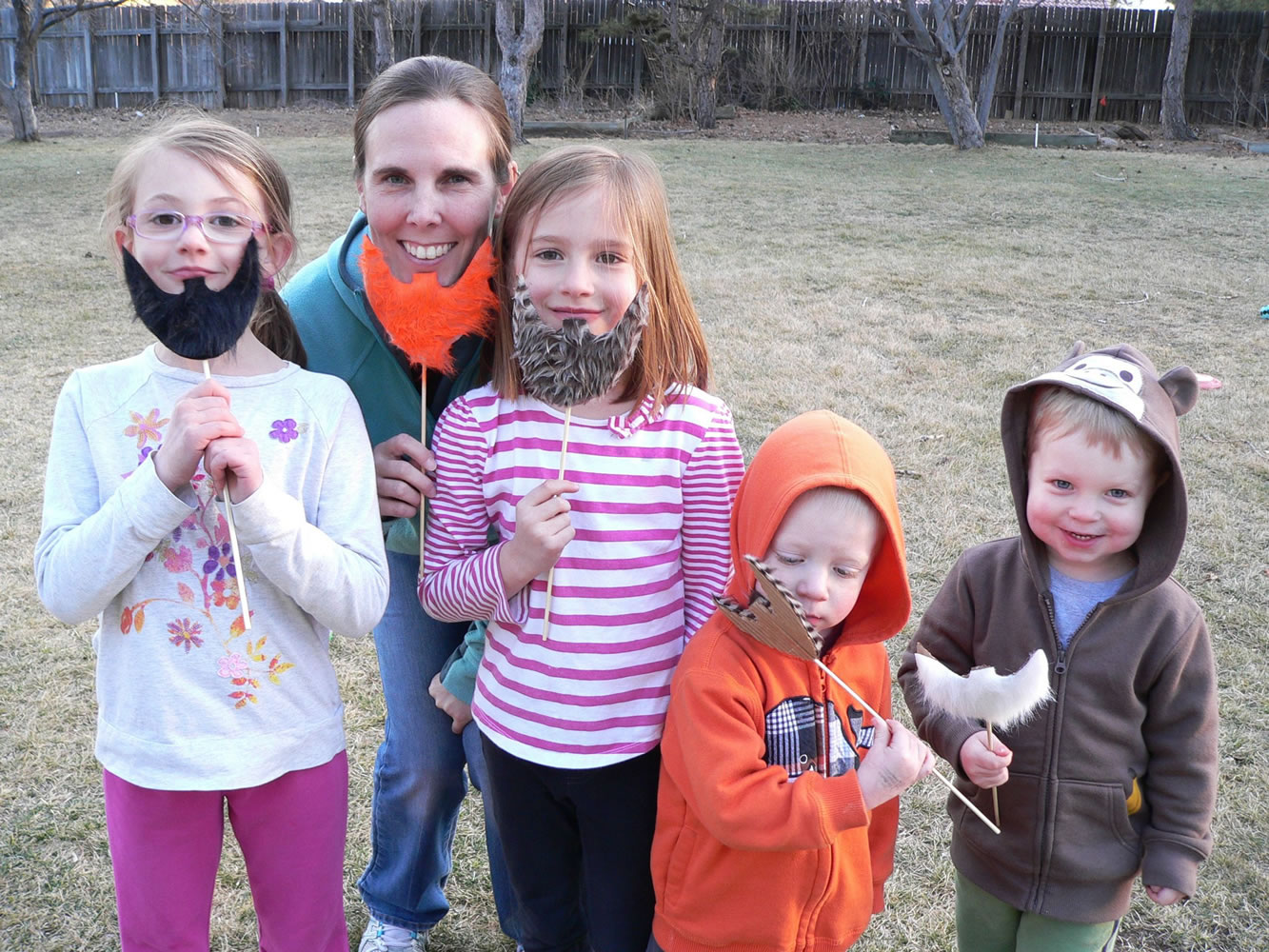 Tatum Marsh, 7, from left, parent Kristi Ainslie, and her children, Riley Ainslie, 6, Dillon Ainslie, 2, and Connor Ainslie, 2, model leprechaun beards made from faux fur and cardboard.