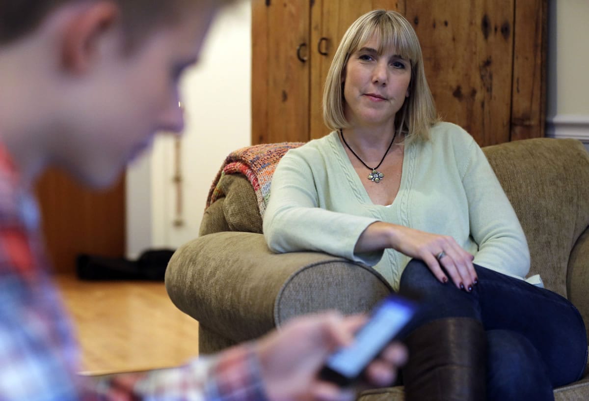 Amy Risinger, right, watches her son Mark Risinger, 16, text at their home in Glenview, Ill., on Oct. 24.