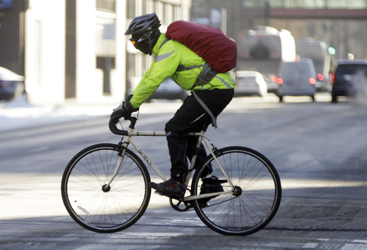 A bicycle rider, his face covered and eyes protected by goggles, braves frigid below-zero temperatures Tuesday in Minneapolis, where conditions are expected to improve in the next few days with warmer temperatures moving in.