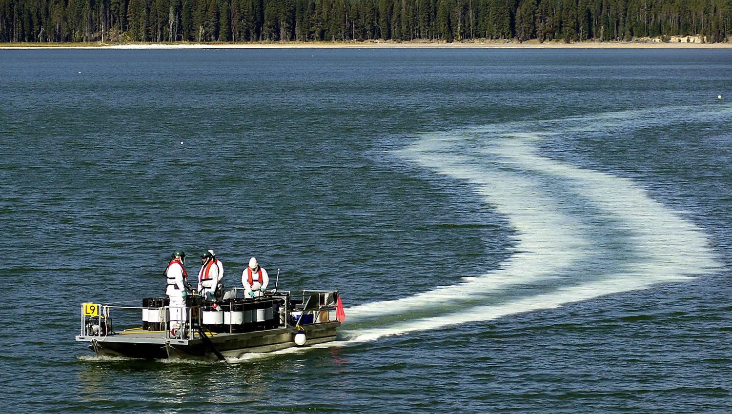 Oregon Department of Fish and Wildlife employees leave a trail of the pesticide rotenone, used to kill tui chub fish, in Diamond Lake, Ore., on Sept. 14, 2006.