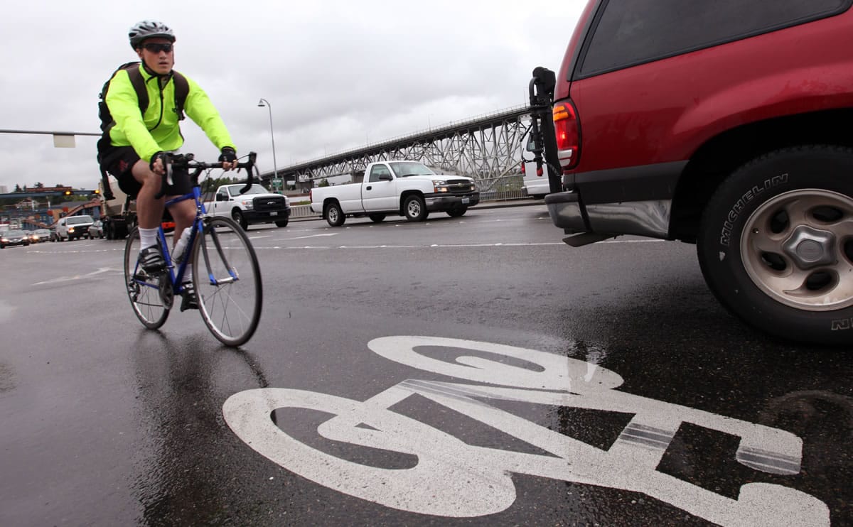 Files/Associated Press
A bicyclist rides in a bike lane during rush hour in Seattle. A recent poll found most people mistrust other drivers while they're driving, biking or walking.