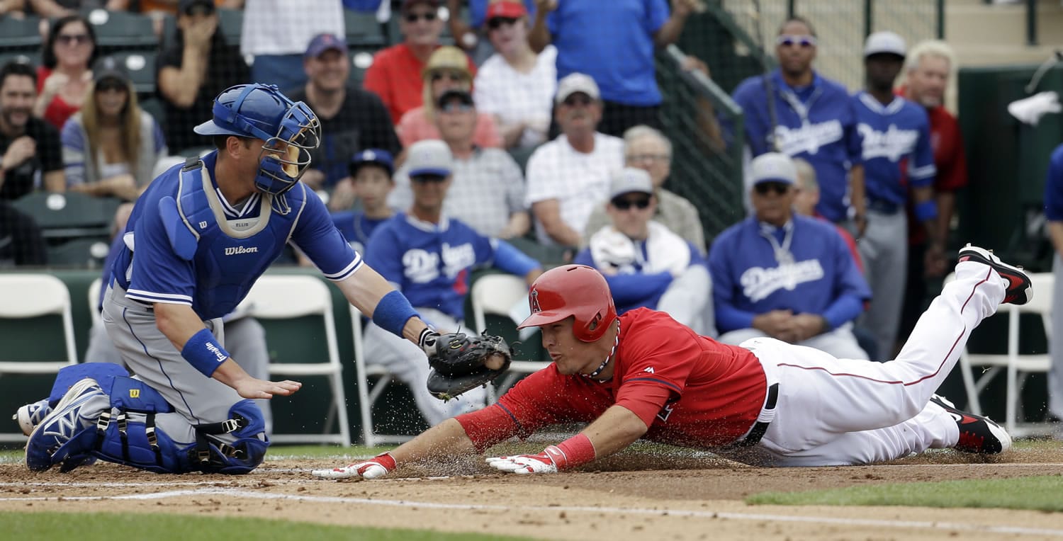 Los Angeles Dodgers catcher A.J. Ellis tags out Los Angeles Angels' Mike Trout at home during the first inning of an exhibition spring training baseball game Thursday, March 6, 2014, in Tempe, Ariz. Trout tried to stretch a triple into an inside the park home run.