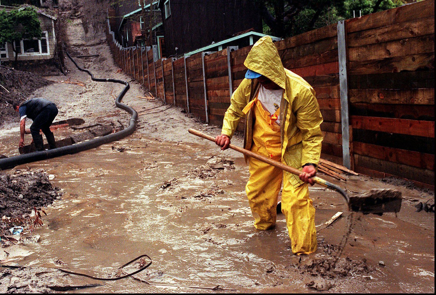 Enrique Lagunas digs a trench to redirect water toward a street in Laguna Beach, Calif., after heavy rains from an El Nino storm hit Southern California on March 25, 1998.