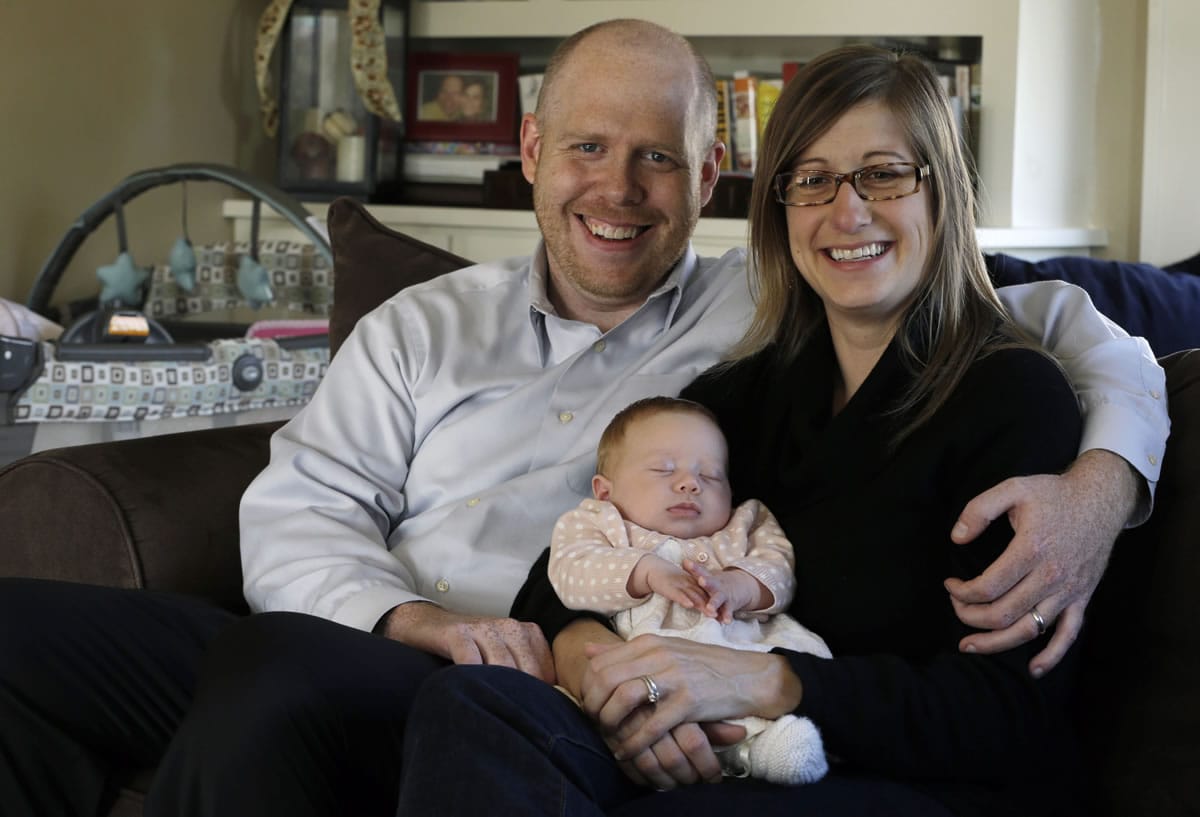 Ken and Abigail Ernst hold their 2-month-old daughter, Lucy, last month. The couple conceived Lucy by using only one embryo through in vitro fertilization.