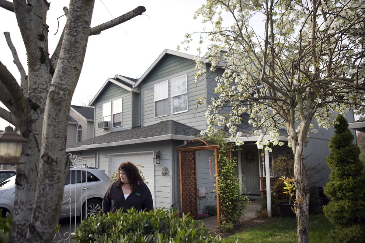 Carol Justice stands in front of her home that is adjacent to the Tualatin River in Cornelius, Ore. in April. When Justice bought her home in 2005, her realtor told her she would not need flood insurance.