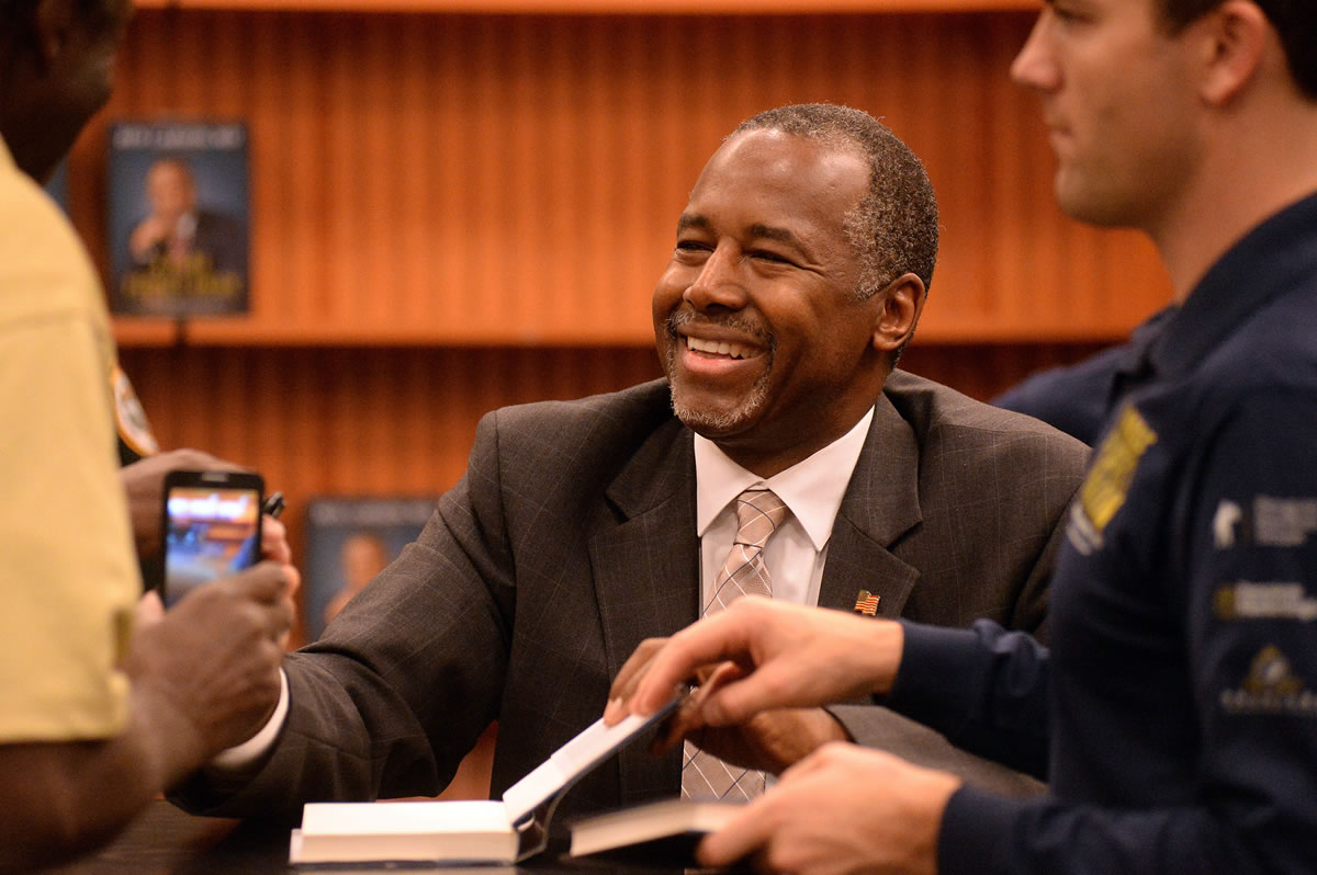 Presidential candidate Dr. Ben Carson smiles and shakes hands Monday with local residents during his book signing event in Lake Sumter Landing, The Villages, Fla.