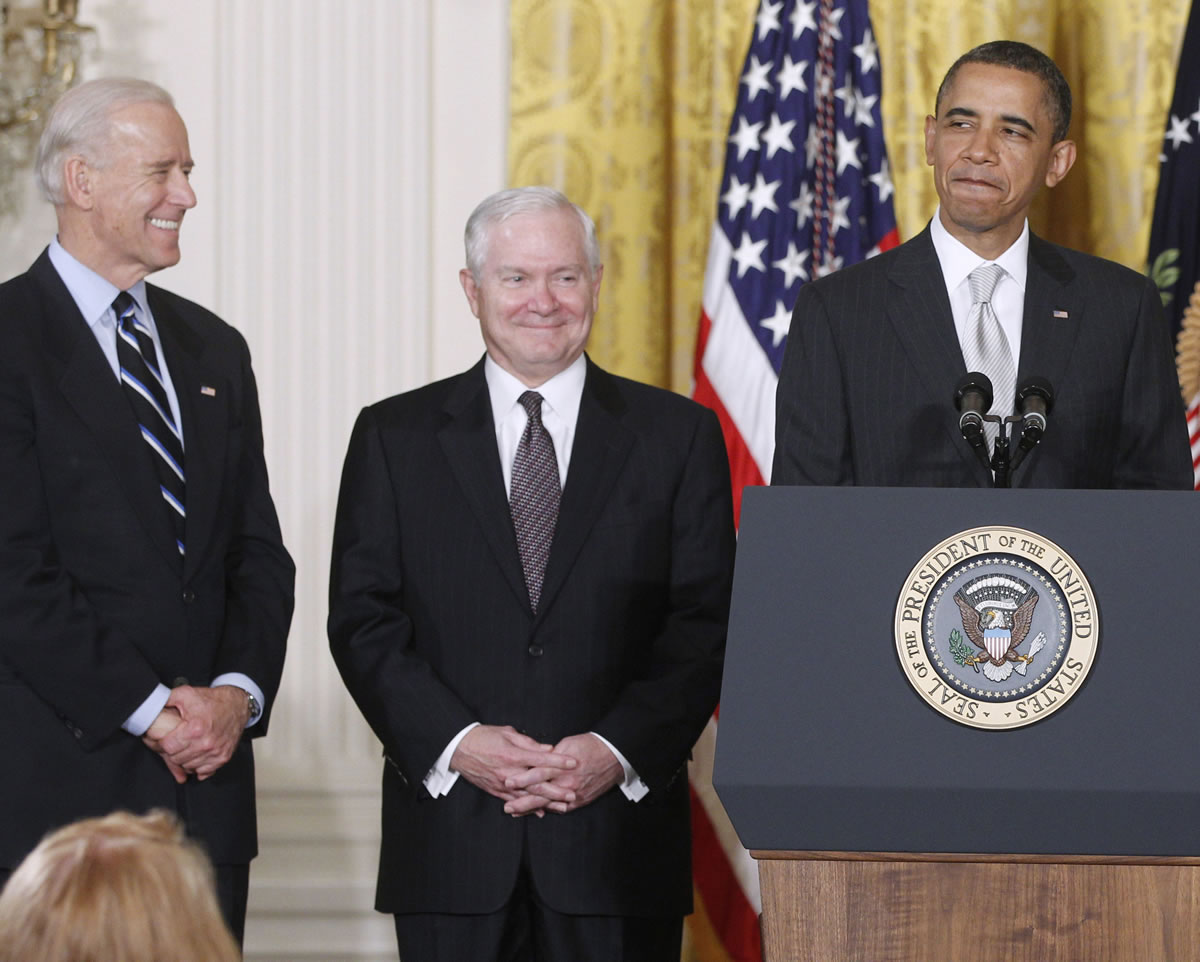 President Barack Obama stands in the East Room of the White House in Washington with, from left: Vice President Joe Biden and outgoing Defense Secretary Robert Gates.