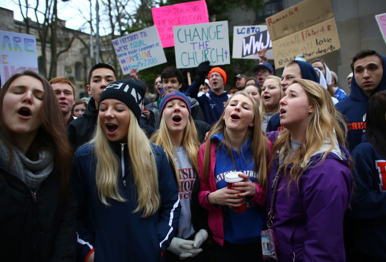 Students sing vocalist Mary Lambert's lyrics to the song &quot;Same Love&quot; by Macklemore &amp; Ryan Lewis outside of the Chancery building for the Archdiocese of Seattle, Friday, Dec. 20, 2013, in Seattle. The students were rallying for Eastside Catholic's Vice Principal Mike Zmuda, who resigned his position after officials with the archdiocese discovered that he was in a same-sex marriage. He was told the marriage violated his contract.